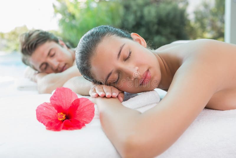 Couple lying on massage table at spa center stock photos Couple lying on massage table at spa center stock photos