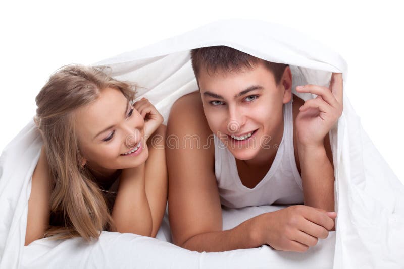 Couple lying on white bed stock photos
