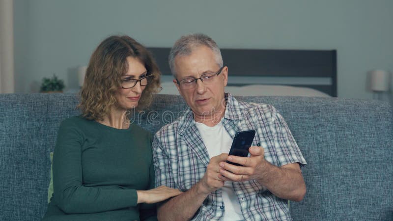 A couple, a man and a woman are discussing something while looking at the phone.