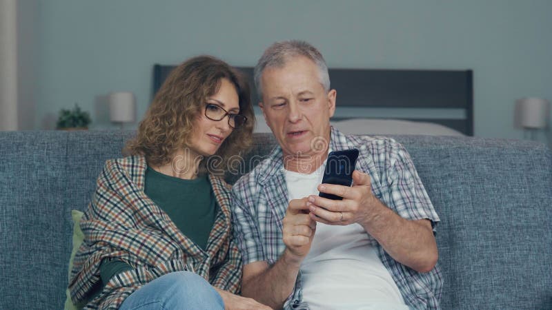 A couple, a man and a woman are discussing something while looking at the phone.