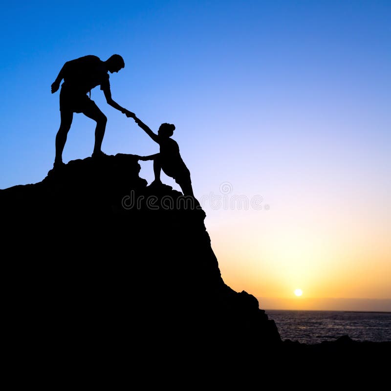 Escursionismo coppia si aiutano a vicenda silhouette in montagna, tramonto e l'oceano.