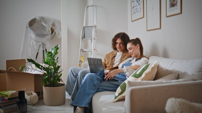 Couple marié utilisant un ordinateur portable dans la nouvelle maison se sentir détendu. homme et femme occasionnel photographie stock