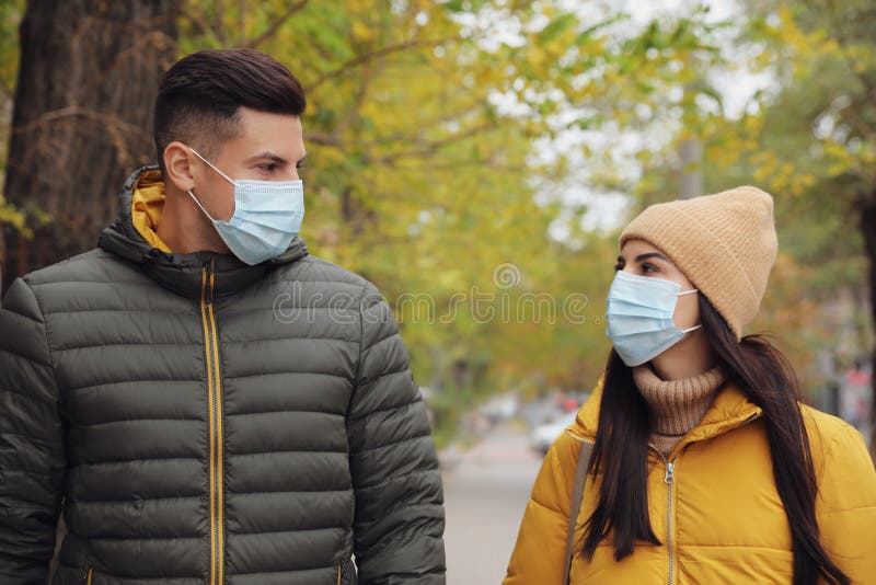 Couple in Medical Face Masks Walking Outdoors. Personal Protection ...