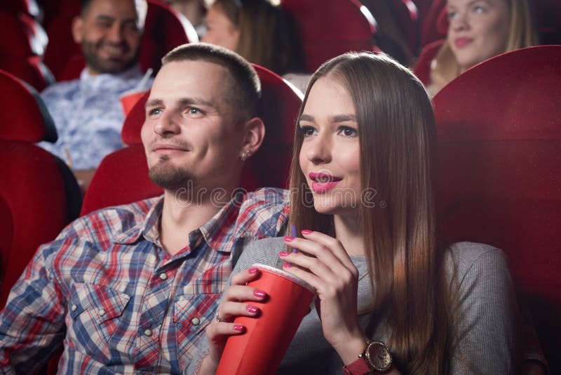 Man In Checked Shirt And Woman In Gray In Cinema.