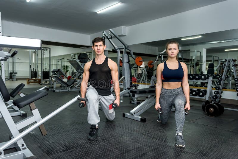 Couple Of Man And Woman Doing Exercises Together In Gym Stock Image