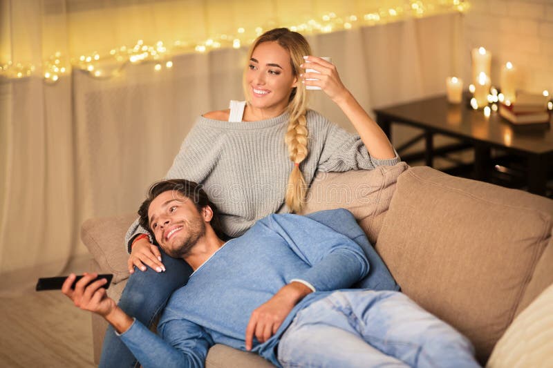 Couple mignon regarder la télévision dans une ambiance chaleureuse photographie stock