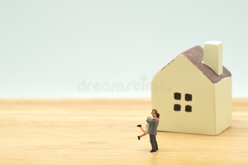 Couple Miniature 2 people standing model with house model make family Feel happy.as background real estate and family concept with stock images Couple Miniature 2 people standing model with house model make family Feel happy.as background real estate and family concept with stock images
