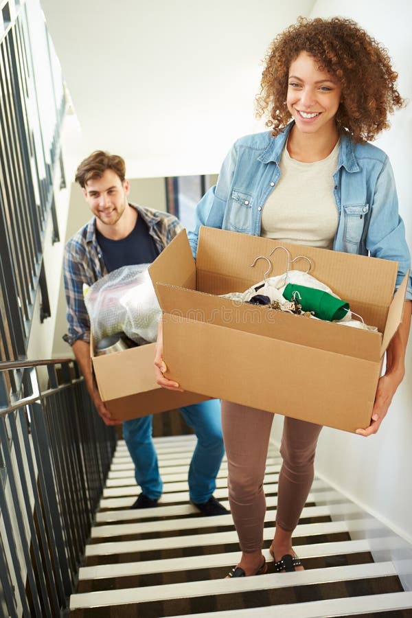 Couple Moving Into New Home Carrying Box Upstairs stock image Couple Moving Into New Home Carrying Box Upstairs stock image