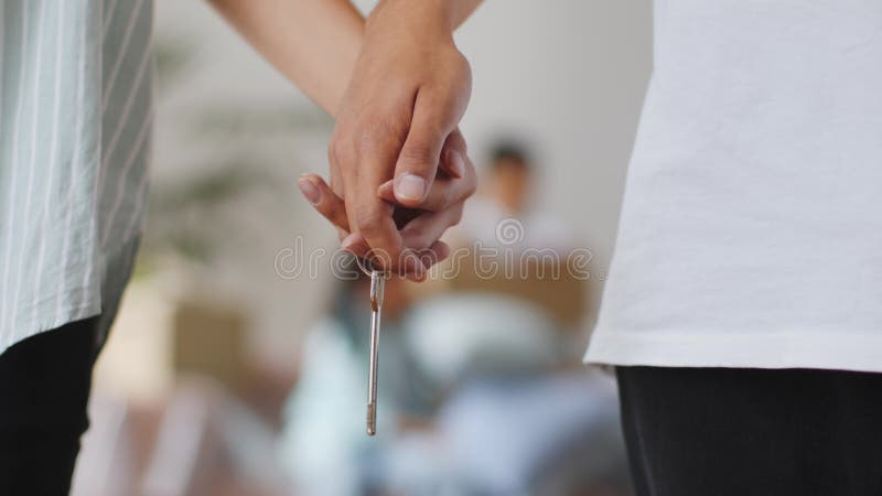 Couple méconnaissable tenant une nouvelle clé de domicile closeup des mains banque de vidéos