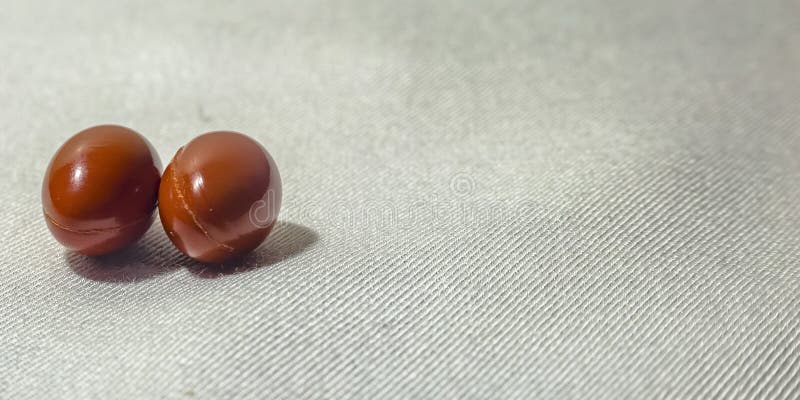 Couple of pills on a white fabric texture surface stock images Couple of pills on a white fabric texture surface stock images
