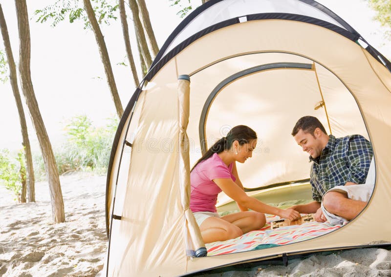 Couple playing boardgame in tent