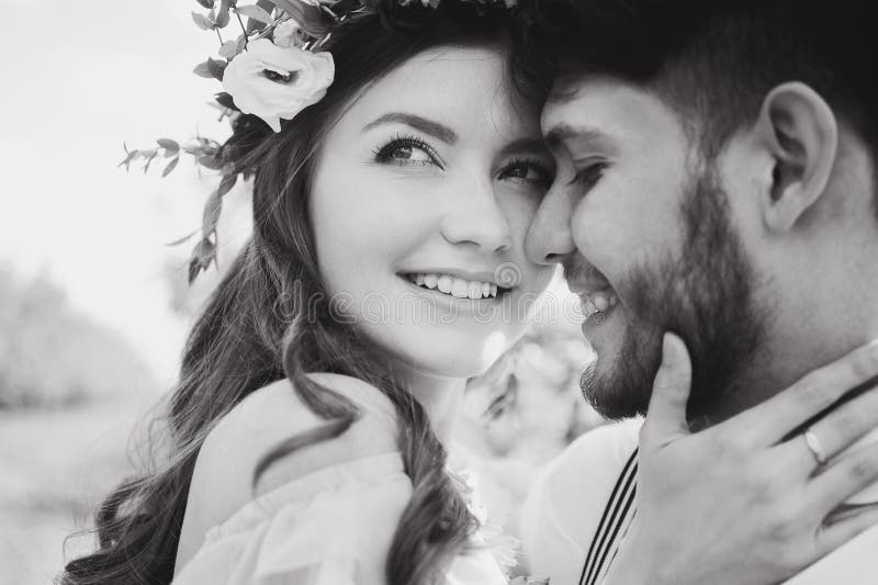 Couple portrait of a girl and guy looking for a wedding dress, a pink dress flying with a wreath of flowers on her head on a backg