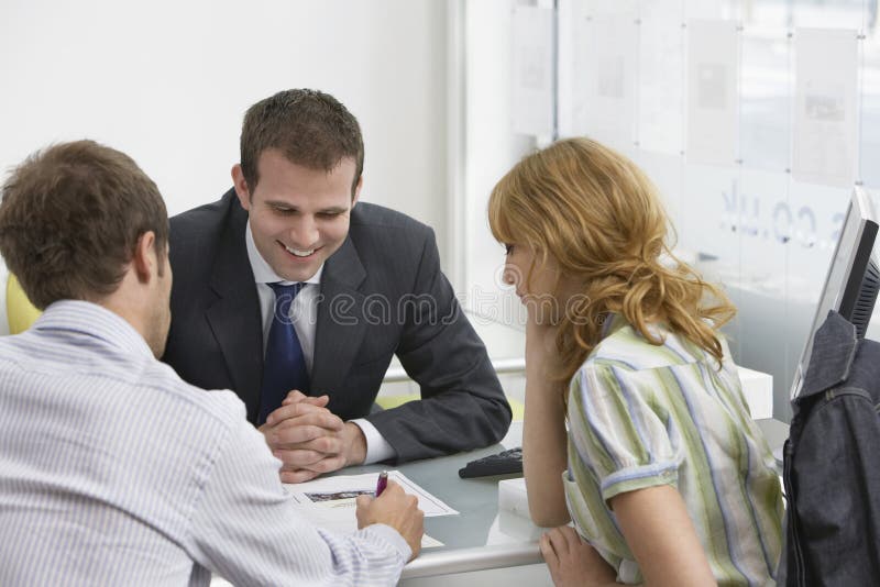 Couple With Real Estate Agent In Office