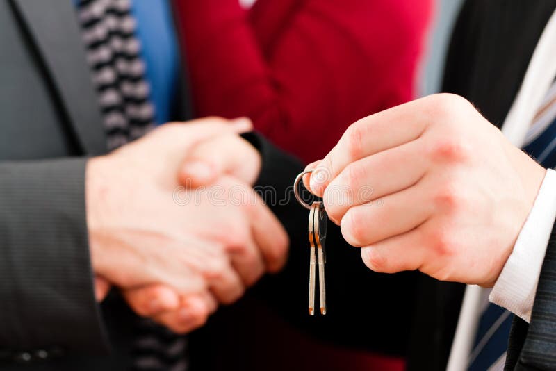 Couple receiving keys from real estate broker stock images Couple receiving keys from real estate broker stock images