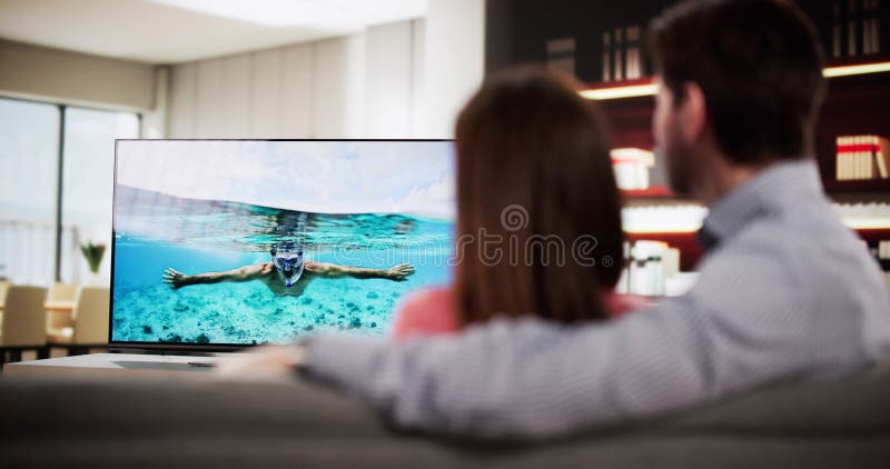 Couple Relaxant sur le canapé Regarder la télévision photographie stock
