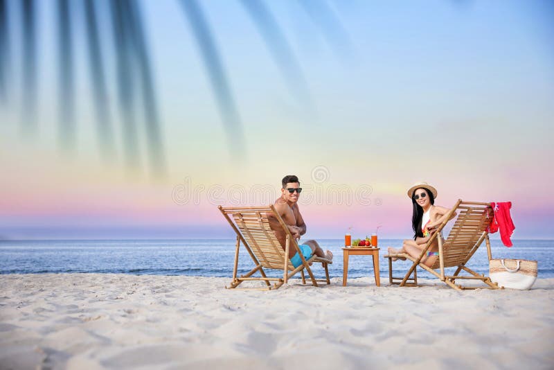 Couple resting on beach at resort