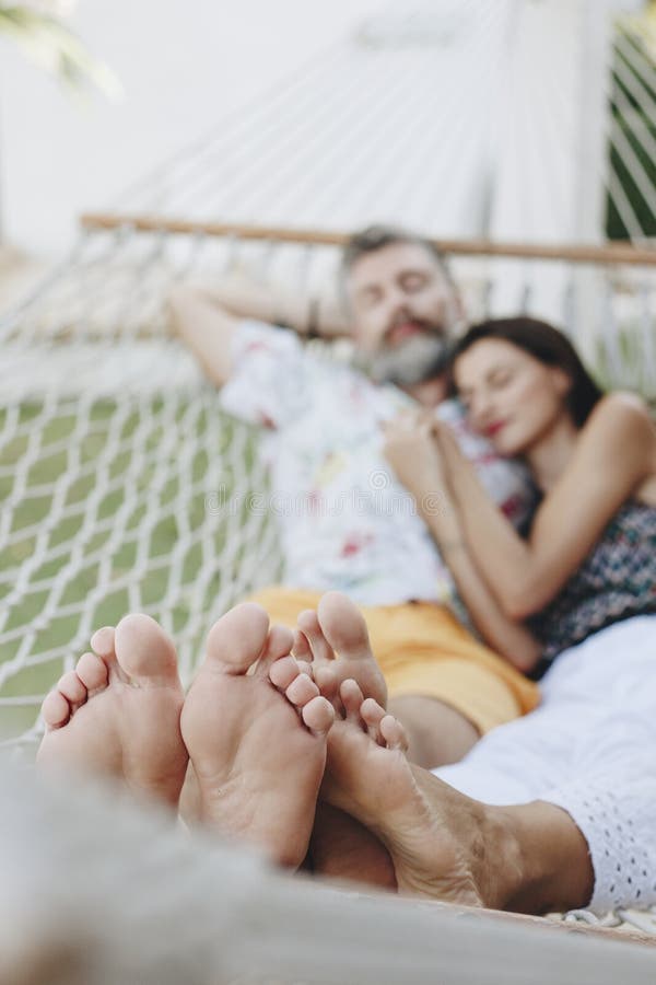 Couple resting together in a hammock stock photo