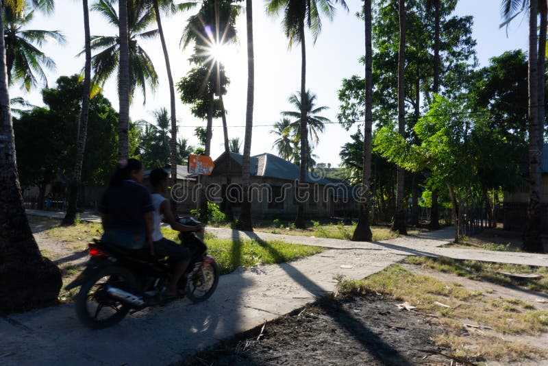 A Couple ride motor cycle on the village road stock photo A Couple ride motor cycle on the village road stock photo