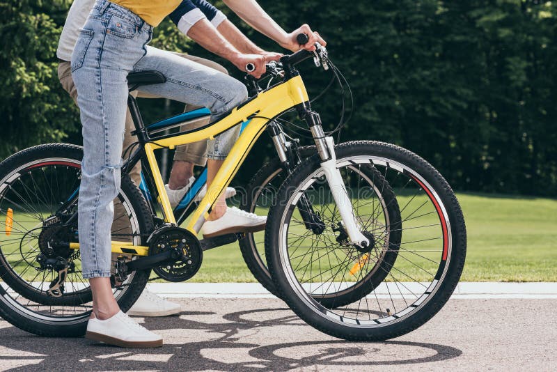 Couple riding bicycles together in park stock image Couple riding bicycles together in park stock image