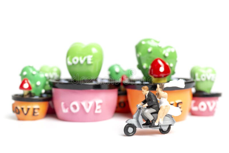 Miniature people : Couple riding the motorcycle in the garden , Valentine`s Day concept