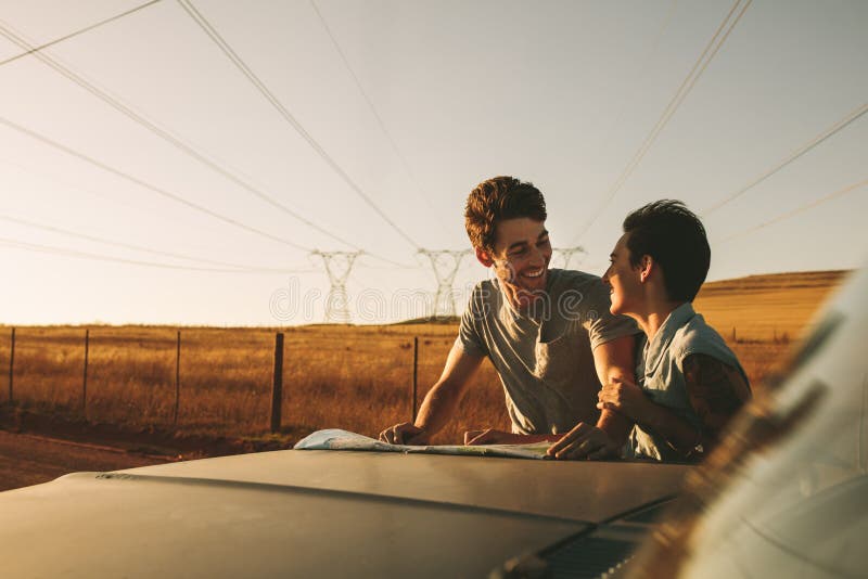 Couple on a road trip looking at map for navigation