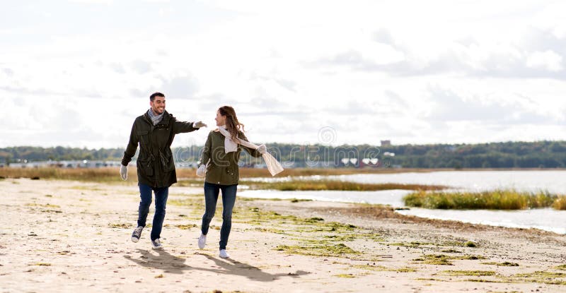 Couple running along autumn beach