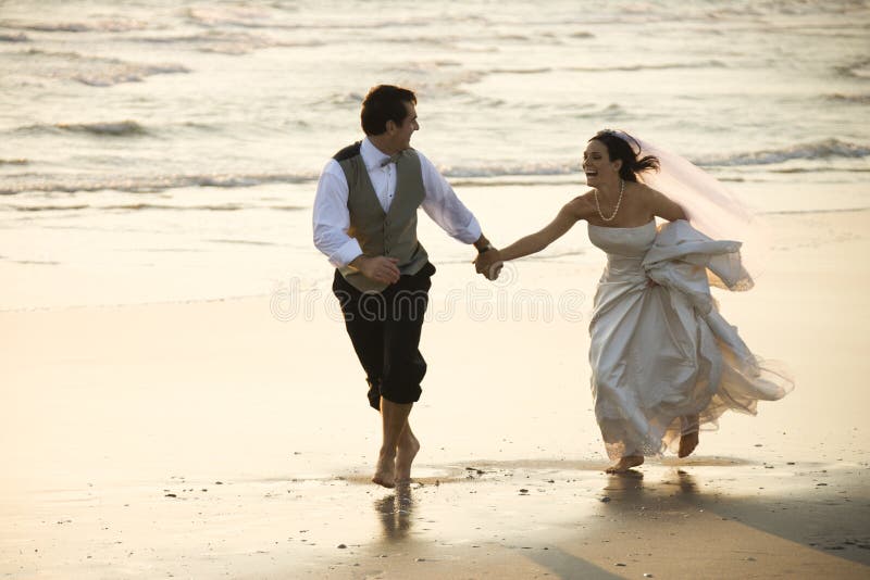 Kavkazský prime dospělý muž ženicha a žena, nevěsta běh naboso na pláži.