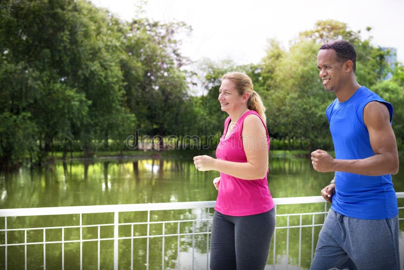 Couple running together in the park royalty free stock photography Couple running together in the park royalty free stock photography