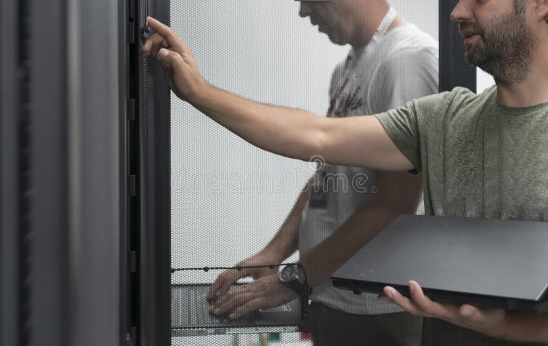 Technicians team updating hardware inspecting system performance in super computer server room or cryptocurrency mining stock photo