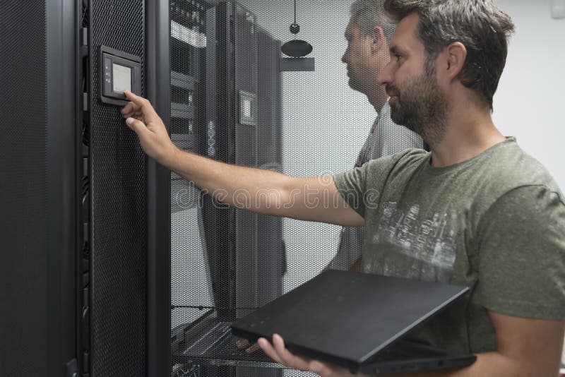 Technicians team updating hardware inspecting system performance in super computer server room or cryptocurrency mining royalty free stock photography