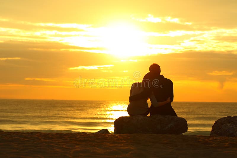 Couple silhouette dating at sunset on the beach