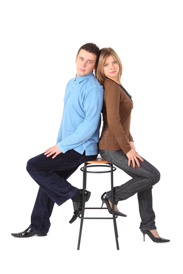 Couple sits on bar stool back to back