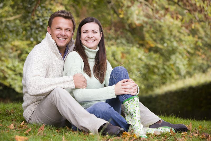 Young couple sitting in autumn woods