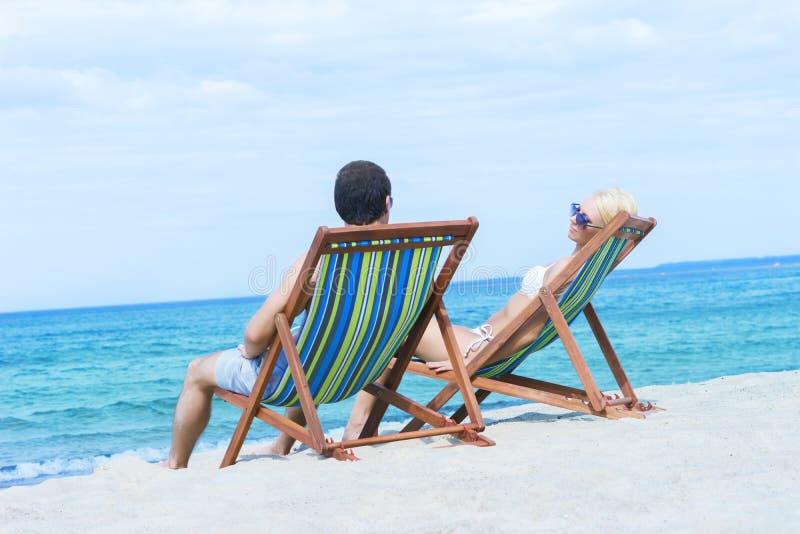 Couple sitting in beach chairs and looking at the sea