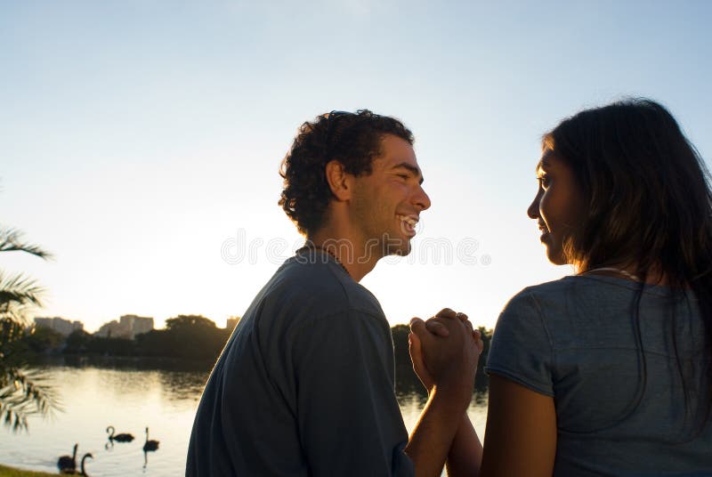 Couple sitting lakeside at a park - Horizontal