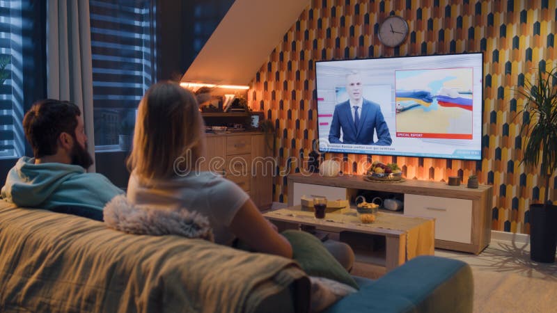 Couple watching TV news about gas conflict