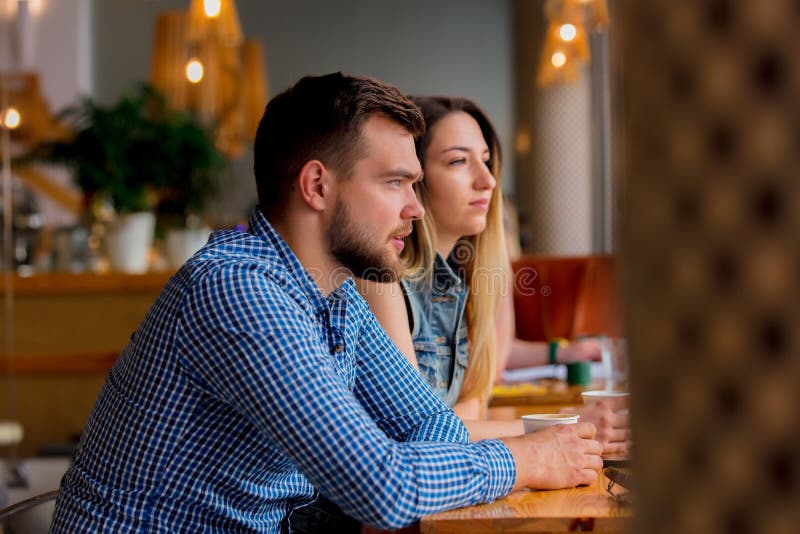 Couple sitting at a table in a cafe and drinking coffee royalty free stock photo Couple sitting at a table in a cafe and drinking coffee royalty free stock photo