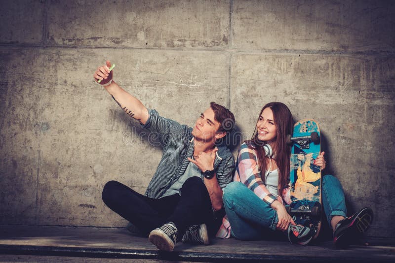 Couple with skateboard taking selfie