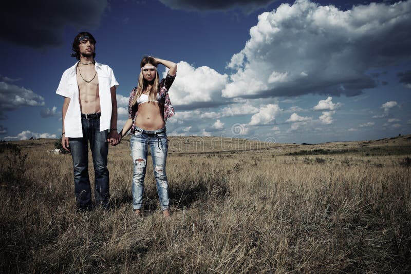 Beautiful young couple hippie posing together over picturesque landscape. Beautiful young couple hippie posing together over picturesque landscape.