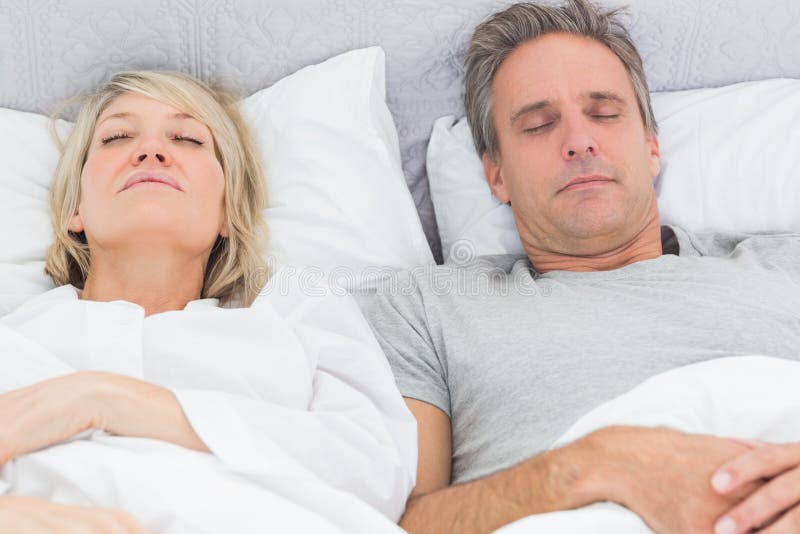 Couple sleeping in their bed at home in bedroom