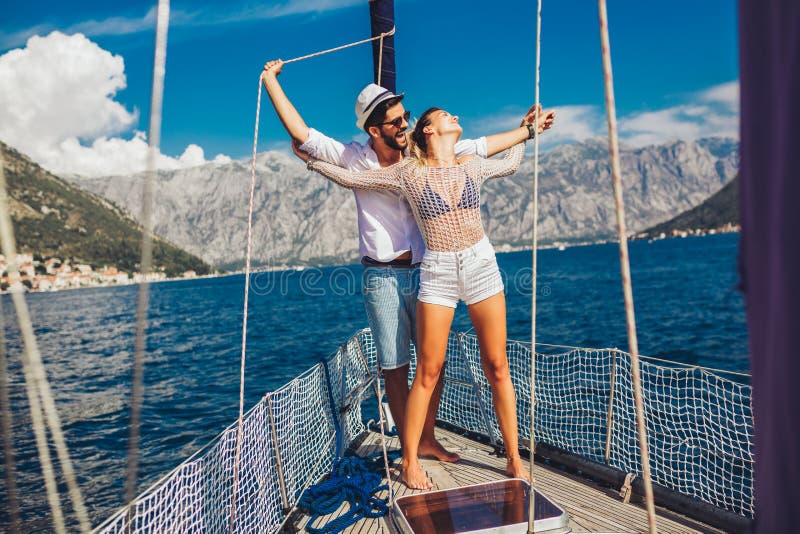 Couple spending happy time on a yacht at sea. Luxury vacation on a seaboat stock photo Couple spending happy time on a yacht at sea. Luxury vacation on a seaboat stock photo