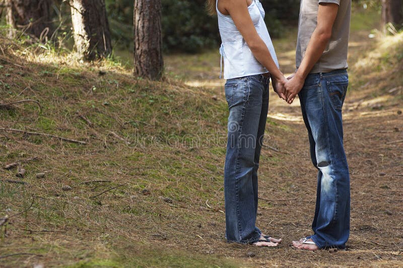 Couple Standing in Forest Holding Hands Low Section Side View Stock ...