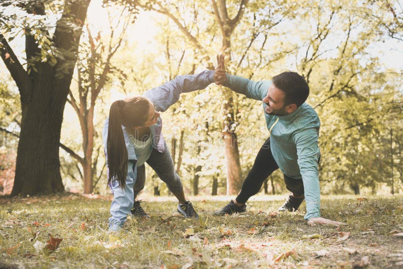 Couple stretching in park. Young couple working exercise togethe stock photography Couple stretching in park. Young couple working exercise togethe stock photography