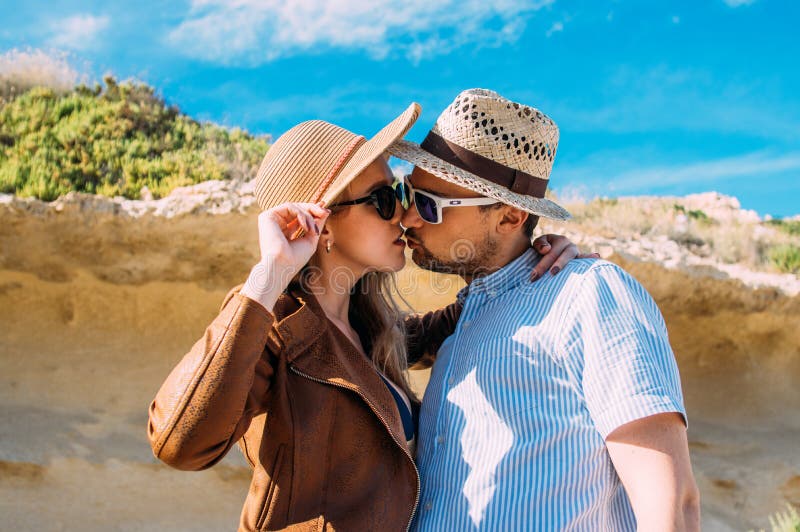 Couple in sunglasses embrace and kissing in the day in the hills royalty free stock photography Couple in sunglasses embrace and kissing in the day in the hills royalty free stock photography
