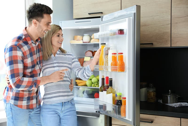 Couple Taking Bottle with Juice Out of Refrigerator Stock Photo - Image ...