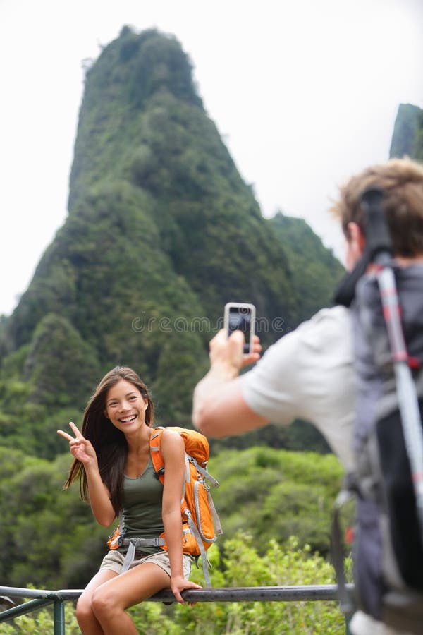 Couple taking photos having fun lifestyle hiking on Hawaii in outdoor activity. Woman and men hiker taking photo pictures with smart phone camera. Iao Valley State Park, Wailuku, Maui, USA. Couple taking photos having fun lifestyle hiking on Hawaii in outdoor activity. Woman and men hiker taking photo pictures with smart phone camera. Iao Valley State Park, Wailuku, Maui, USA.