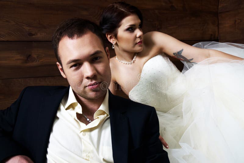 Couple in their wedding clothes in barn with hay