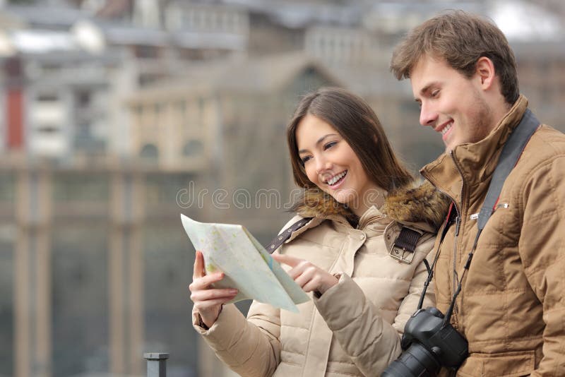 Couple of tourists consulting a guide in winter