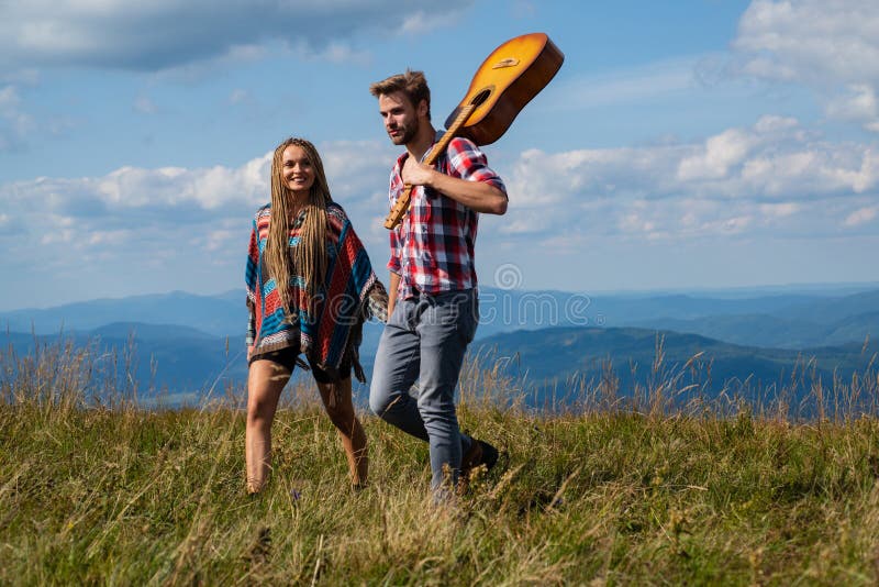 Couple travelers Man and Woman follow holding hands at sunny mountains landscape on background. Couple in love. royalty free stock image Couple travelers Man and Woman follow holding hands at sunny mountains landscape on background. Couple in love. royalty free stock image