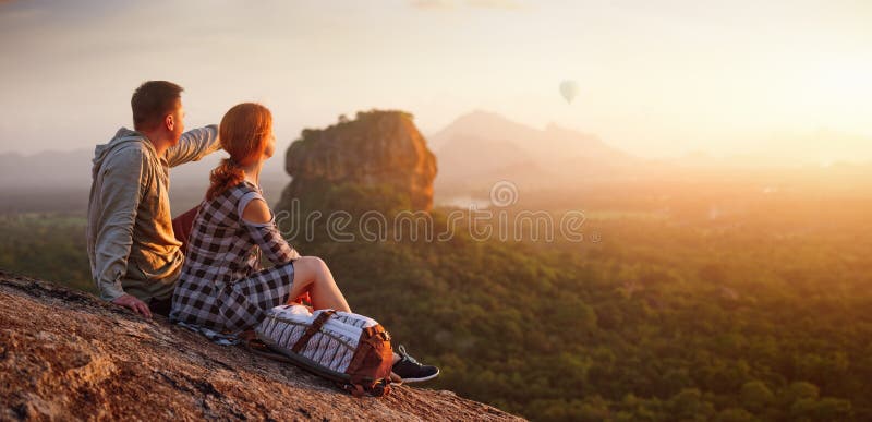 Couple travelers watch beautiful sunset near famous rocky plateau Lion peak, Sigiriya. Sri Lanka